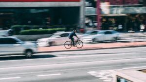 Das Bild zeigt einen Radfahrer im Stadtverkehr.